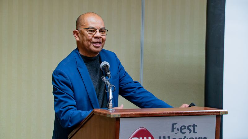 A guest speaker addresses the room from the podium
