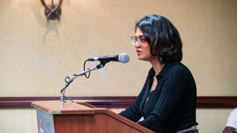 A young woman shares her perspective at the microphone